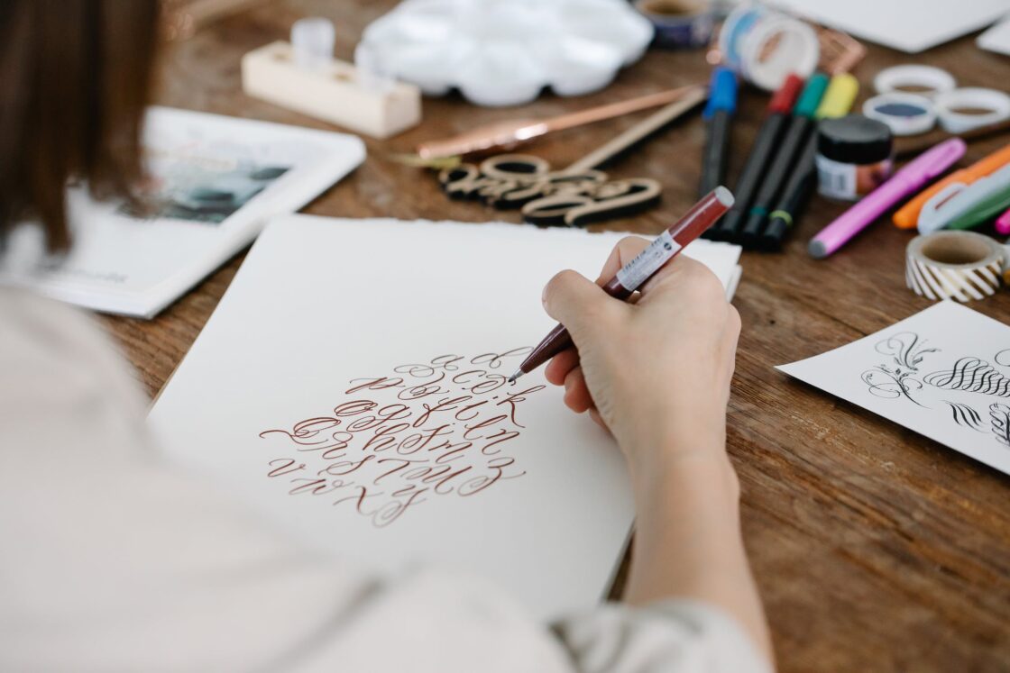 A girl writing calligraphy on white paper