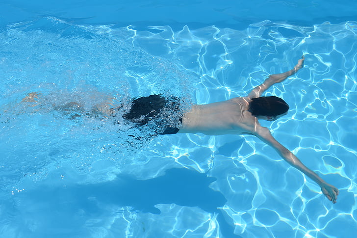 A boy swimming in a swimming pool