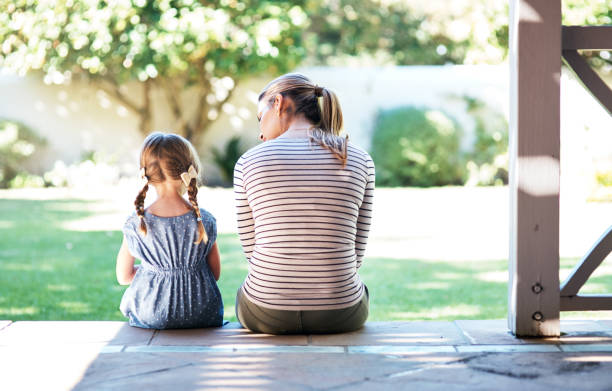 A mother and child sitting on a step, talking